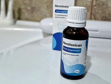Пузырек капель Revotoxican на столе.